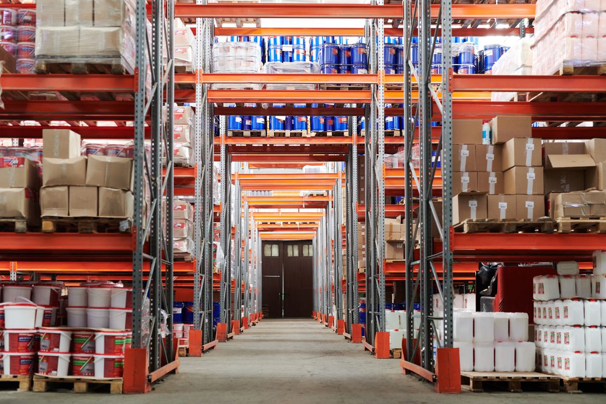 Distribution center commercial cleaning crew servicing racking aisles in an Orlando warehouse